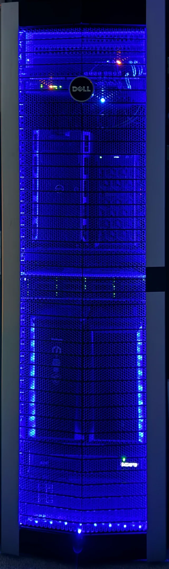 Full-height server rack with its front doors closed, lit blue from inside